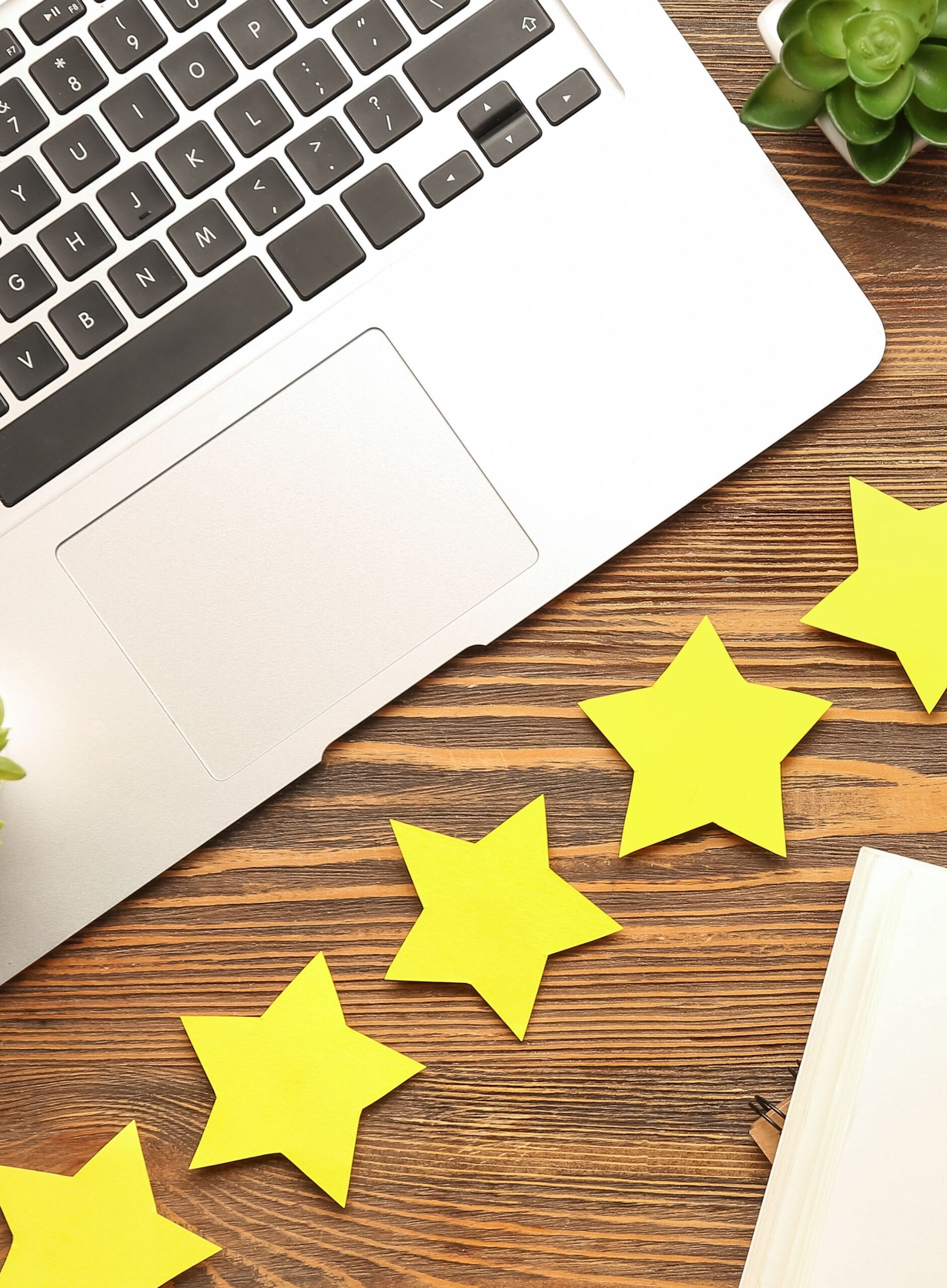 Laptop with paper stars scattered around, illustrating strategies for enhancing customer service in small businesses.